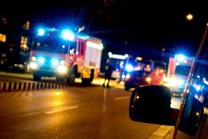 emergency vehicles at crash scene at night with lights flashing