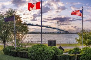 canada and us flag near bridge to detroit
