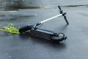 fallen scooter lying on wet road