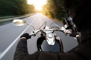 image of motorcyclist riding on a rural road