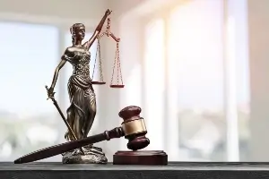 Image of "Lady Justice" statuette and gavel on desk